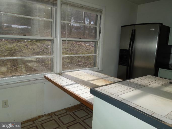 953 Pine Grove Road Bluemont, VA 20135 - Photo 4 of 25 a kitchen with kitchen island a sink and a refrigerator