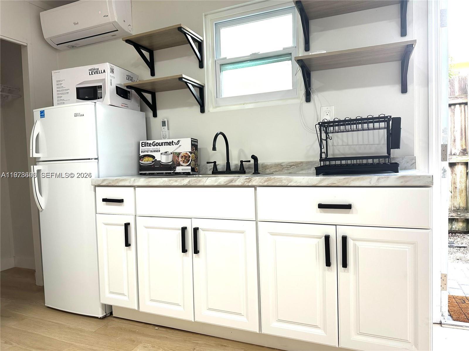 8235 Southwest 41st Terrace, Unit 1 Miami, FL 33155 - Photo 2 of 8 a kitchen with stainless steel appliances a refrigerator and a sink