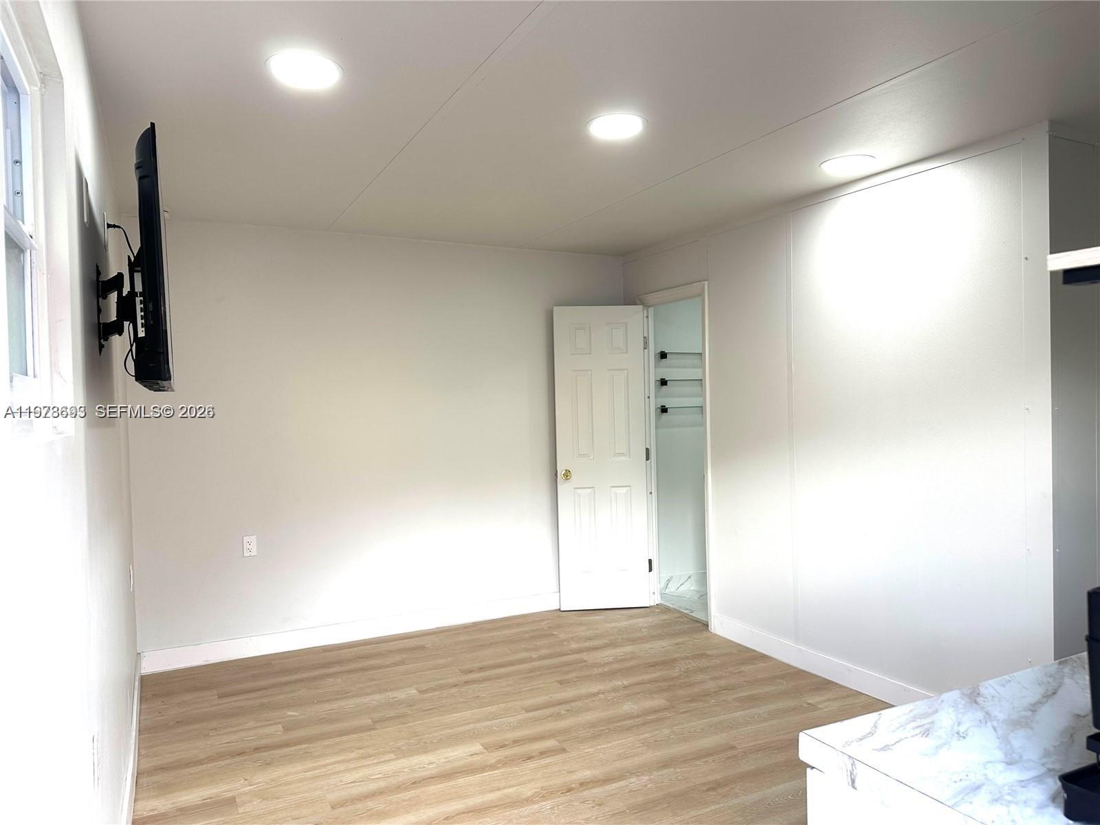 8235 Southwest 41st Terrace, Unit 1 Miami, FL 33155 - Photo 3 of 8 a view of a room with wooden floor and bathroom