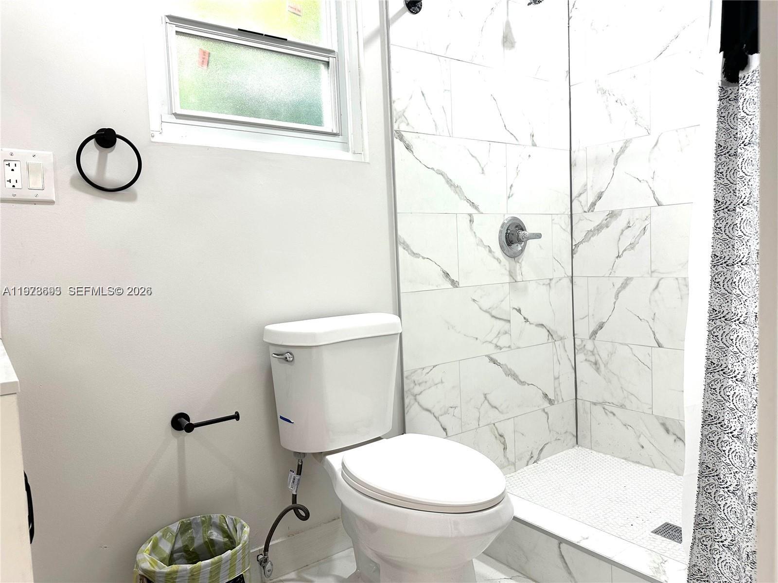 8235 Southwest 41st Terrace, Unit 1 Miami, FL 33155 - Photo 8 of 8 a white toilet sitting next to a bathroom sink