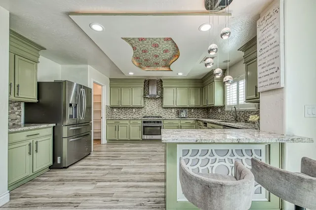 a kitchen with stainless steel appliances granite countertop a sink and a refrigerator