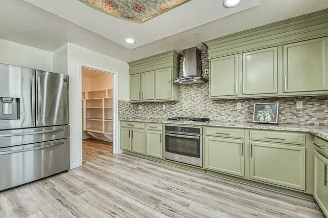 a kitchen with stainless steel appliances granite countertop a stove a sink and a refrigerator