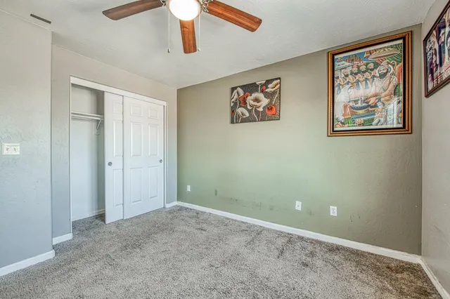 an empty room with wall painting and fan