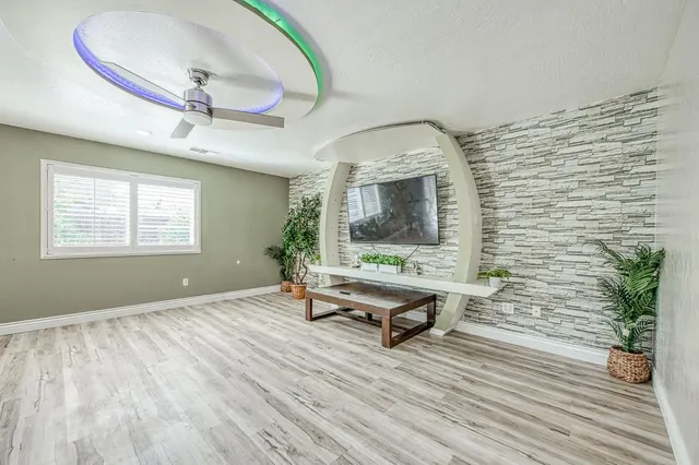 a living room with furniture floor to ceiling window and wooden floor