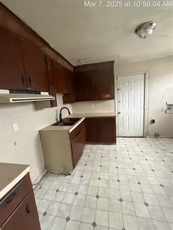 a kitchen with granite countertop a sink a stove and cabinets