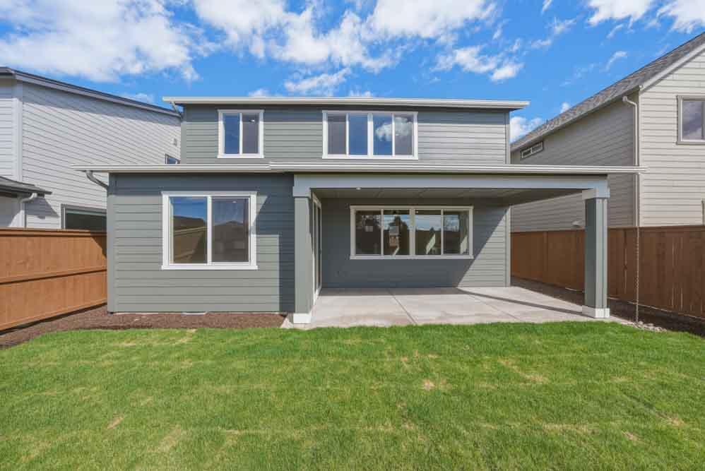 3915 Northeast Oakside Loop Bend, OR 97701 - Photo 8 of 27 a front view of a house with a garden and yard