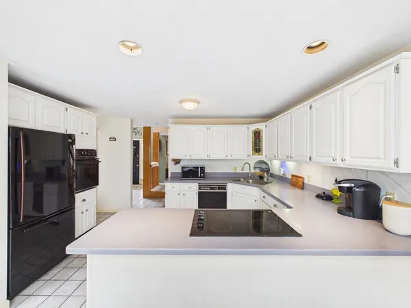 a kitchen that has a lot of cabinets a sink and appliances