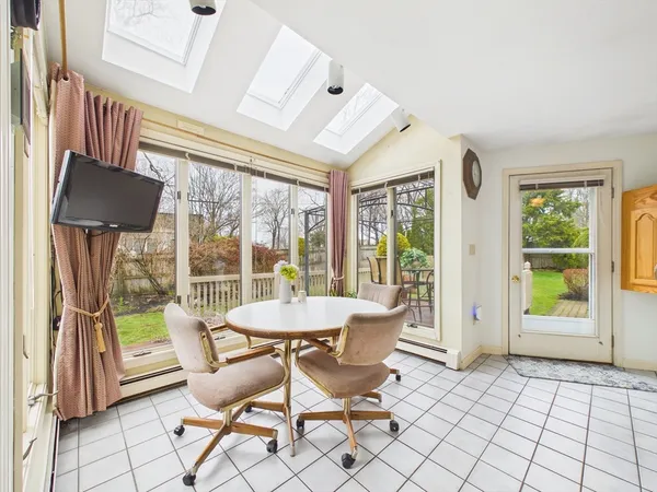 a dining room with furniture and large windows