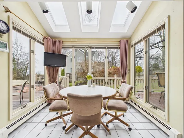 a dining room with furniture a chandelier and glass door