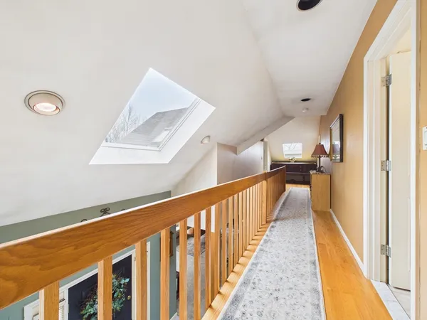 a view of a hallway with wooden floor and staircase