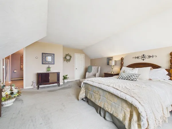 a spacious bedroom with a bed and chair