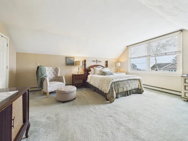 a bedroom with bed and a large window