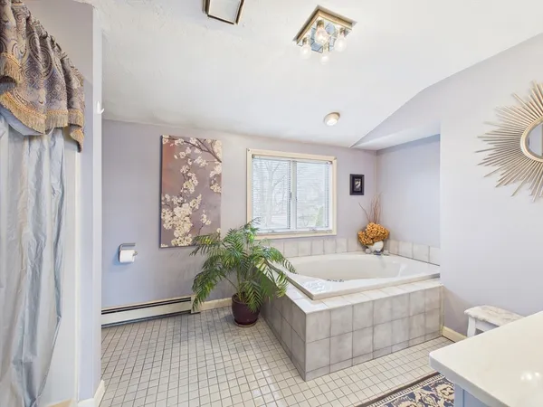 a white bath tub sitting in a bathroom next to a window