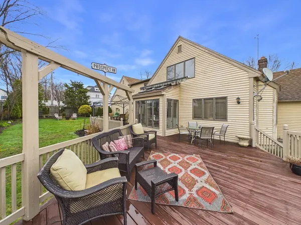 a view of a patio with couches chairs dining table and chairs with wooden floor