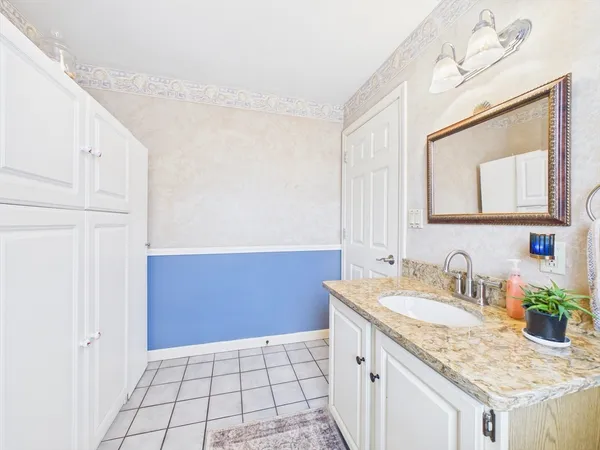 a bathroom with a granite countertop sink and a mirror