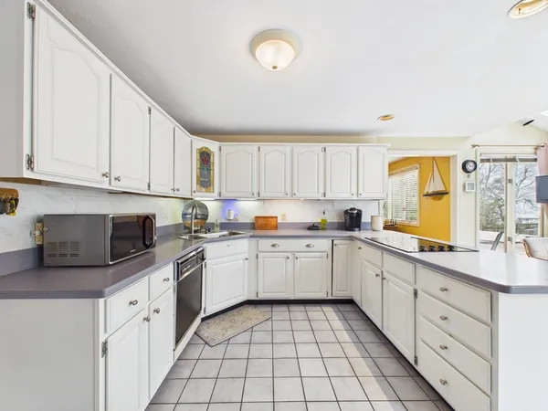 a kitchen with cabinets appliances a sink and a window