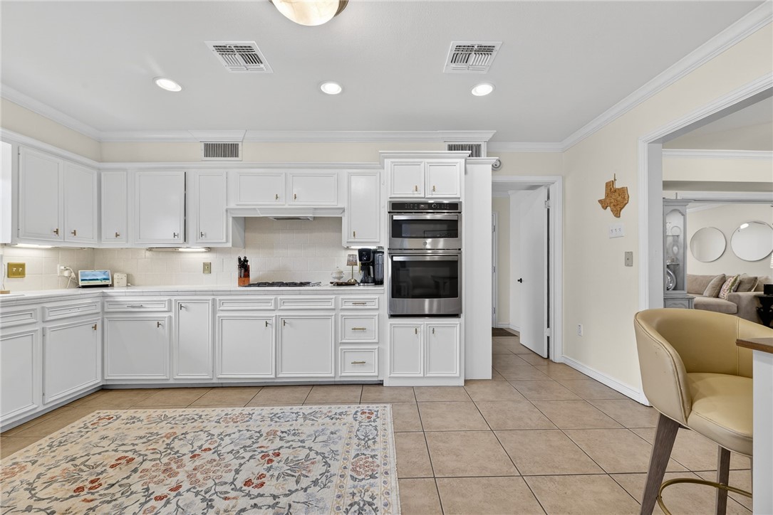 609 Peerman Place Corpus Christi, TX 78411 - Photo 11 of 36 a kitchen with stainless steel appliances granite countertop a refrigerator and a stove top oven