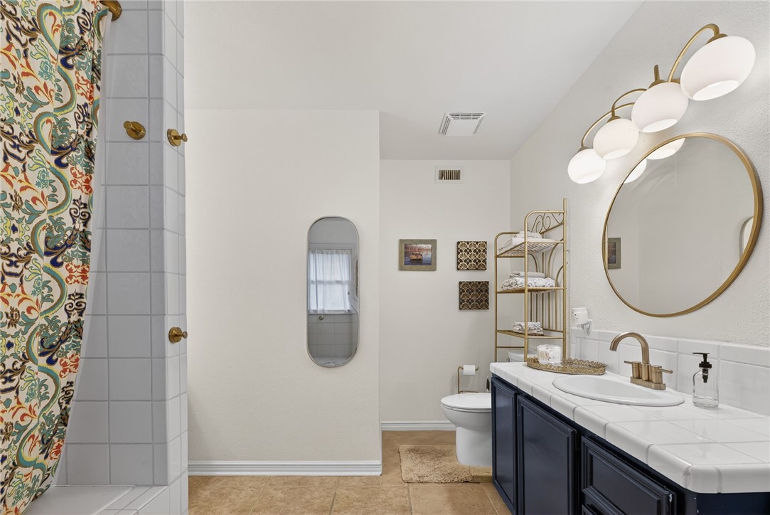 609 Peerman Place Corpus Christi, TX 78411 - Photo 26 of 36 a bathroom with a double vanity sink and mirror