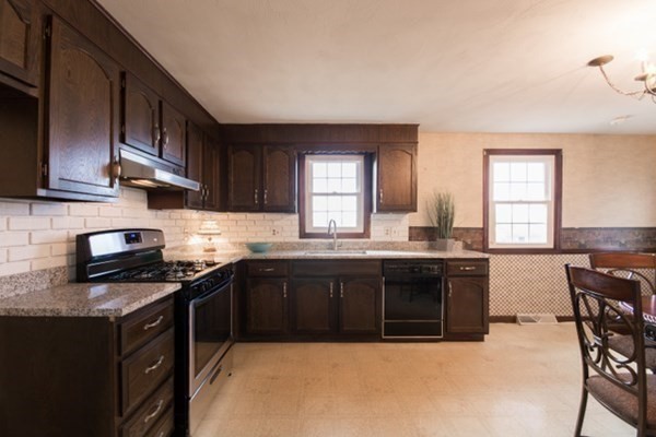 320 Quincy Street Fall River, MA 02720 - Photo 6 of 21 a kitchen with stainless steel appliances granite countertop a stove a sink dishwasher a microwave oven and a refrigerator with wooden cabinets