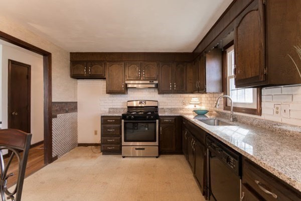 320 Quincy Street Fall River, MA 02720 - Photo 7 of 21 a kitchen with stainless steel appliances granite countertop a stove a sink and a microwave