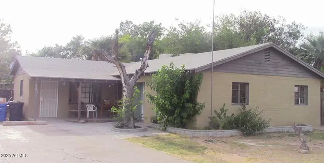 a view of a house with backyard and trees
