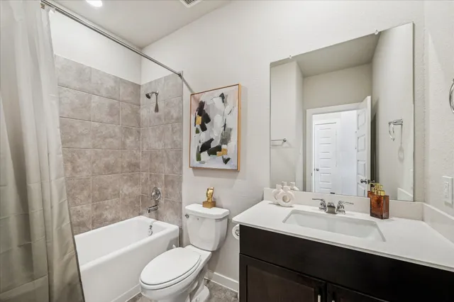 a bathroom with a toilet a sink a mirror a bathtub and vanity