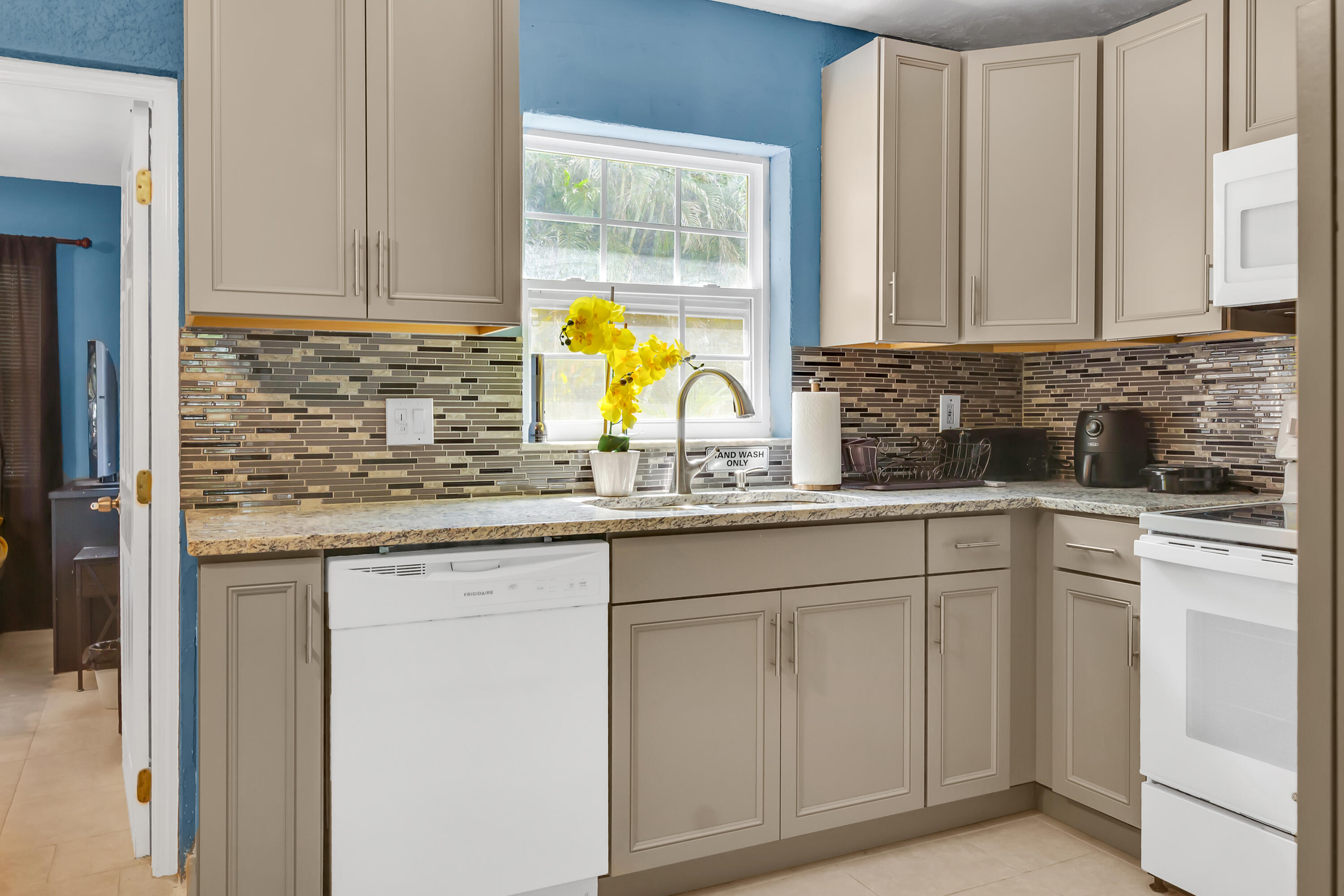 4340 Wilkinson Drive Lake Worth, FL 33461 - Photo 6 of 12 a kitchen with white cabinets and sink