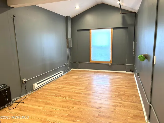 a view of a big room with wooden floor and windows