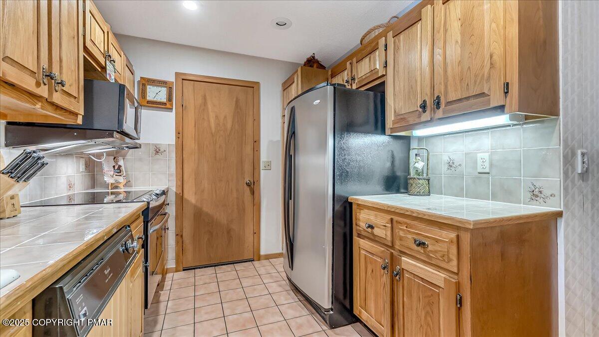 297 Forest Drive Canadensis, PA 18325 - Photo 15 of 58 a kitchen with stainless steel appliances granite countertop a refrigerator a stove and a sink with wooden cabinets