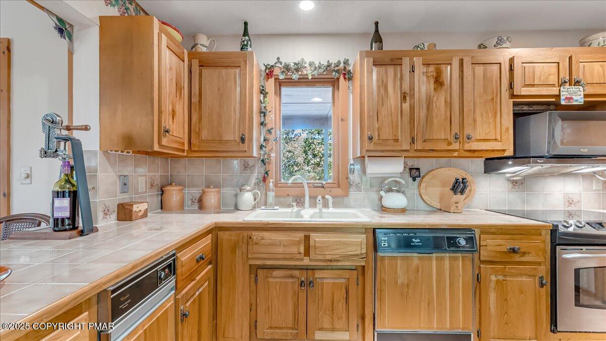 297 Forest Drive Canadensis, PA 18325 - Photo 16 of 58 a kitchen with stainless steel appliances granite countertop a sink a refrigerator and a wooden cabinets