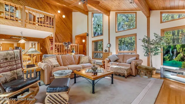 a living room with fireplace furniture and a large window
