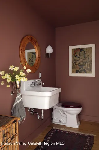 a bathroom with a toilet a sink and mirror