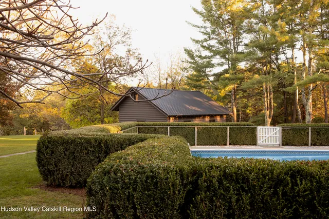 a view of a house with a big yard plants and large trees