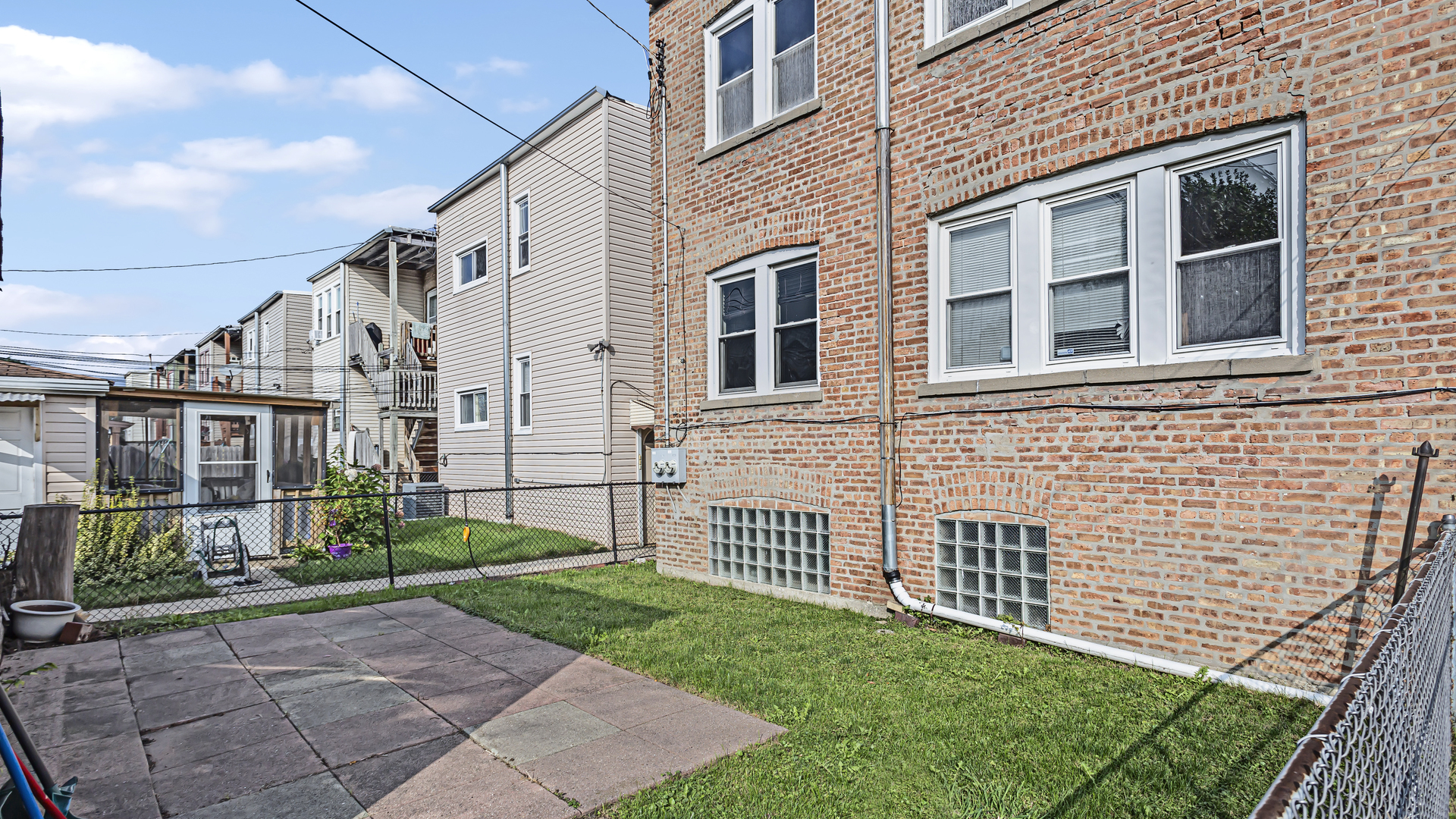 1712 North Monitor Avenue Chicago, IL 60639 - Photo 29 of 33 a view of a brick house with many windows next to a yard