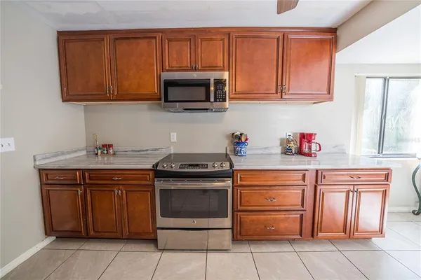 a kitchen with stainless steel appliances granite countertop a stove microwave and cabinets