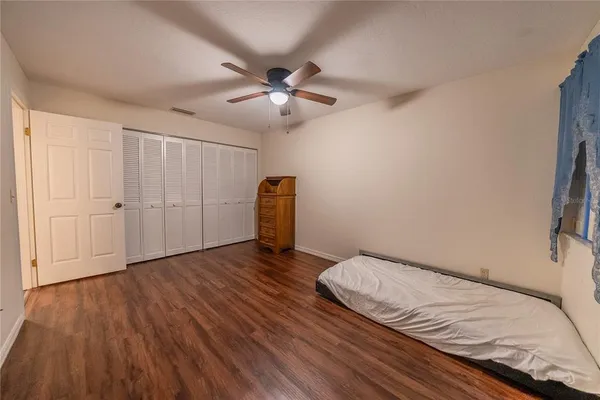 a view of a room with wooden floor and a ceiling fan