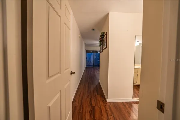 a view of a hallway with wooden floor and staircase