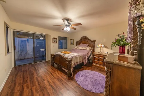 a bedroom with a bed dresser and a potted plant