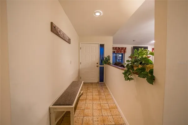 a hallway with a white cabinets and wooden floor