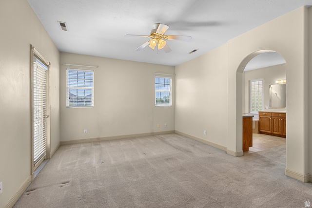 389 North Main Street St. George, UT 84770 - Photo 15 of 44 Unfurnished bedroom with arched walkways, multiple windows, and light colored carpet