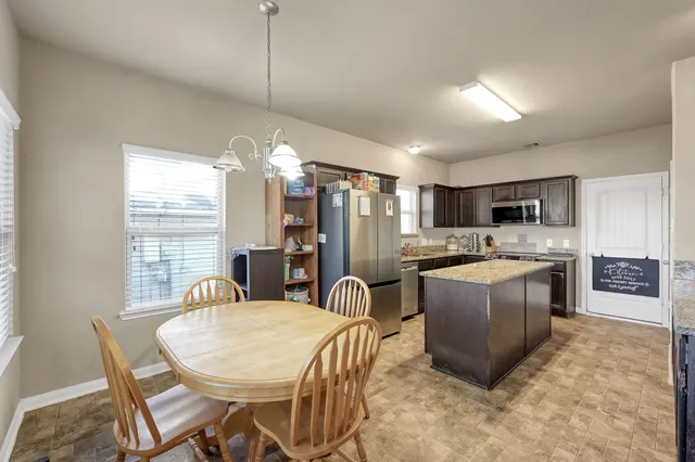 a kitchen with sink a refrigerator and chairs