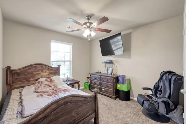 a bedroom with a bed couch and flat screen tv