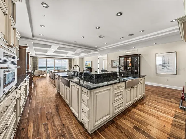 a kitchen with stainless steel appliances a dining table chairs stove and cabinets