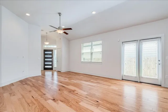 a view of an empty room with a window and wooden floor