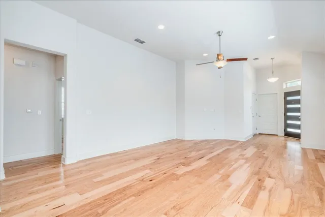 a view of empty room with wooden floor