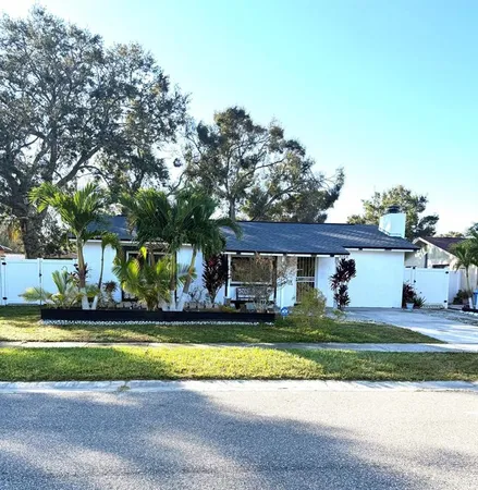 a view of a house with a big yard and large trees