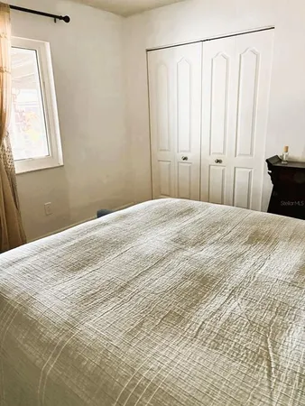 a bedroom with a bed and a window