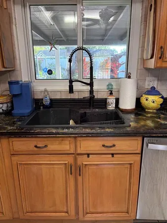a living room with granite countertop white cabinets and a wooden floor