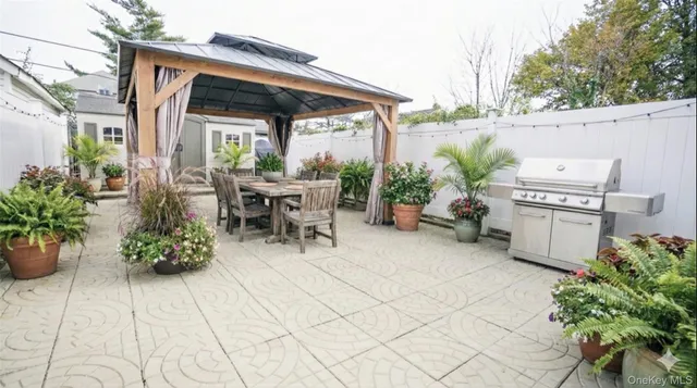 a view of a patio with table and chairs potted plants with wooden fence