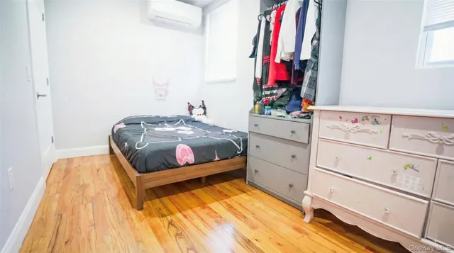 a bedroom with a bed and a mirror on the dresser
